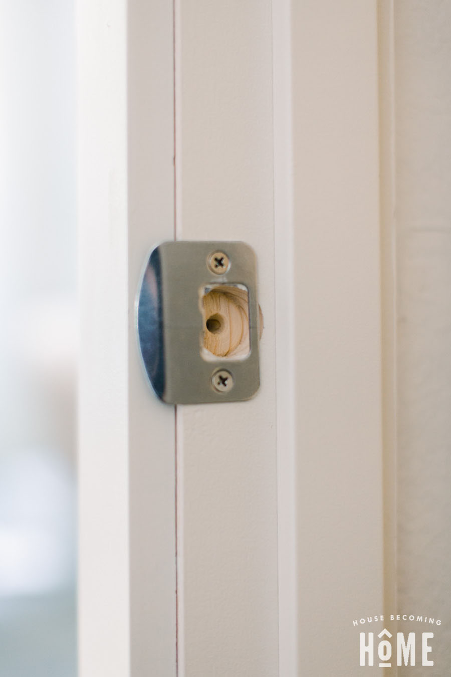 Hole for latch plate on door jamb. Putting on door knob, screwing in latch plate.