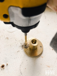 Make Holes in the Brass Flange to attach toilet paper holder to cabinet